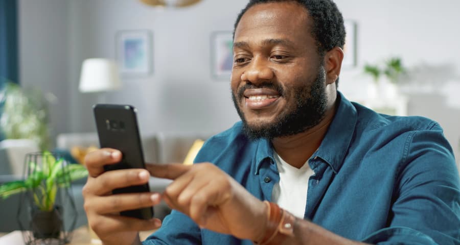 Man at home using an app on his cell phone